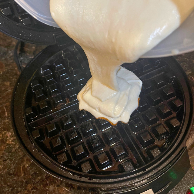Pouring Waffle Batter into a hot Waffle Iron