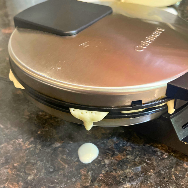 waffle batter spilling out of the waffle maker