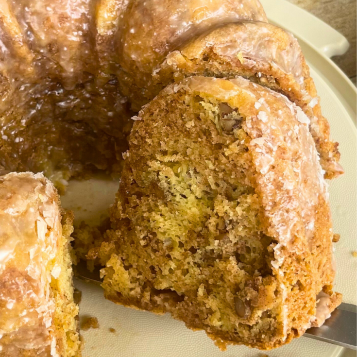 A slice of Honey Bun Cake being lifted off the cake platter