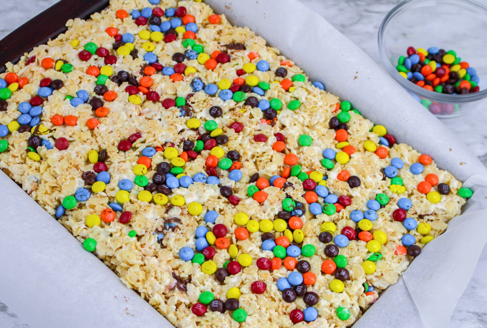 A baking sheet pan filled with M&M Rice Krispies Treats ready to cut