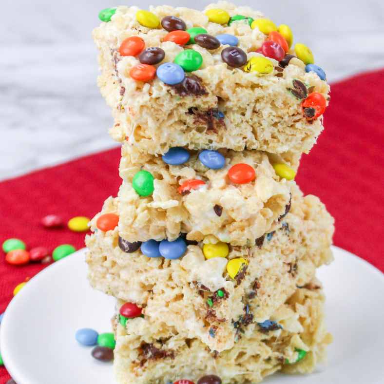 M&M Rice Krispies Treats cut into squares and stacked on a white dish