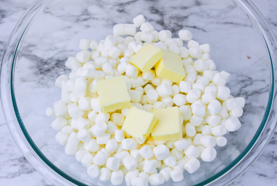 Mini marshmallows and butter pats in a microwave safe bowl