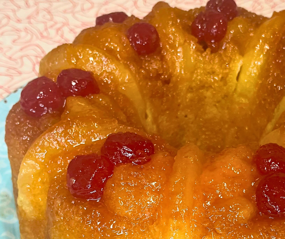 Pineapple Upside Down Bundt Cake with cherries and pineapple rings on top.