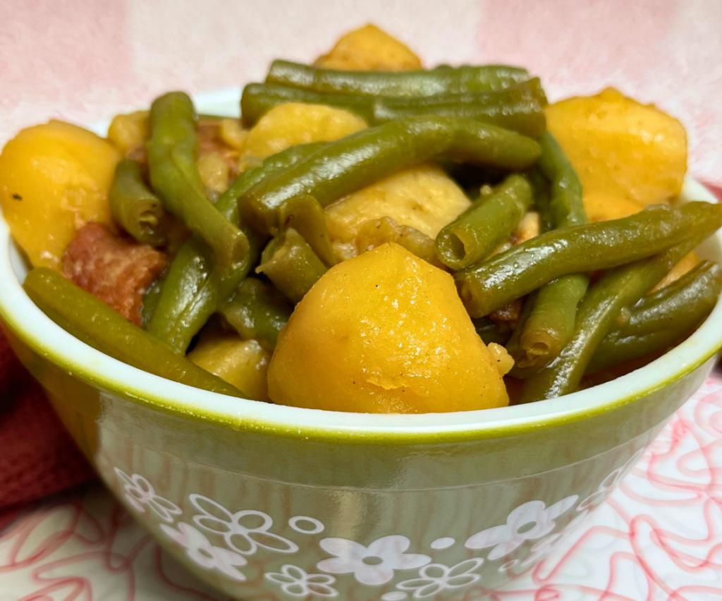 Green beans with potatoes, onions and bacon in a serving bowl