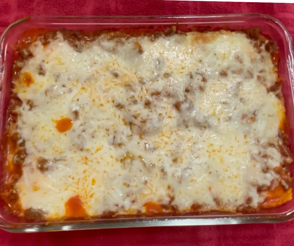 Baked Ravioli in a glass baking dish with melted mozzarella cheese on top